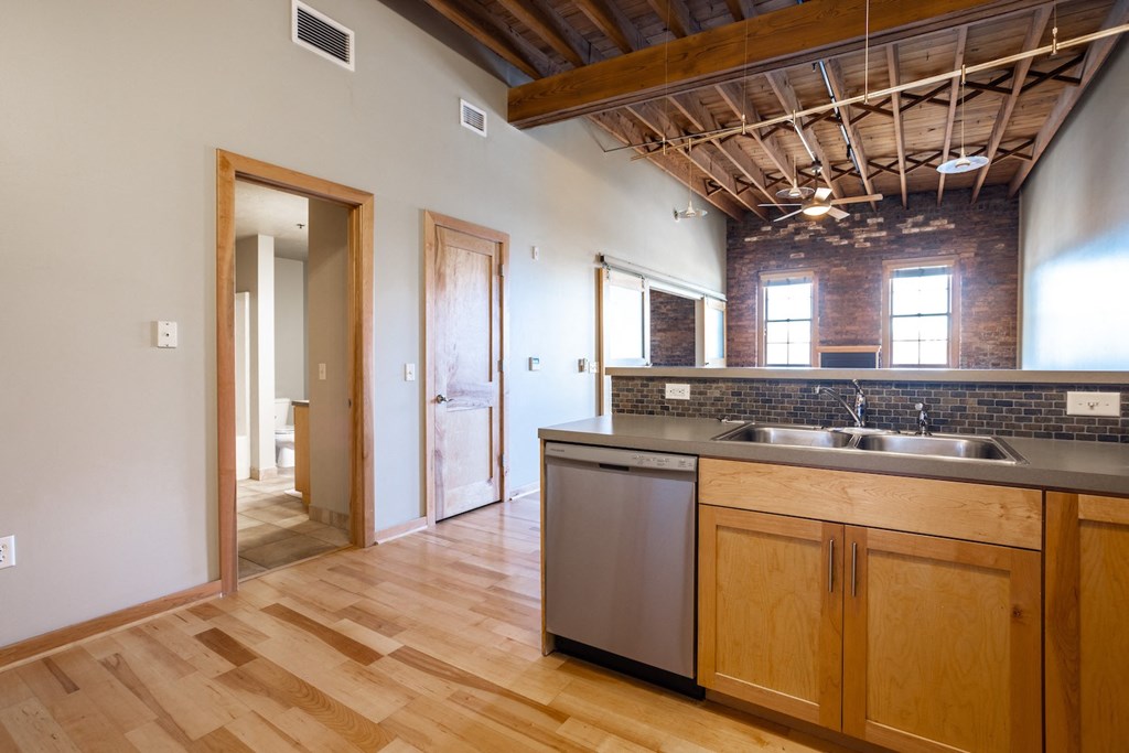 the view from the kitchen into the living room and the entryway to the bedroom