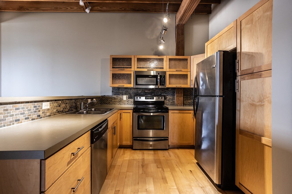 a kitchen with stainless steel appliances and wooden cabinets