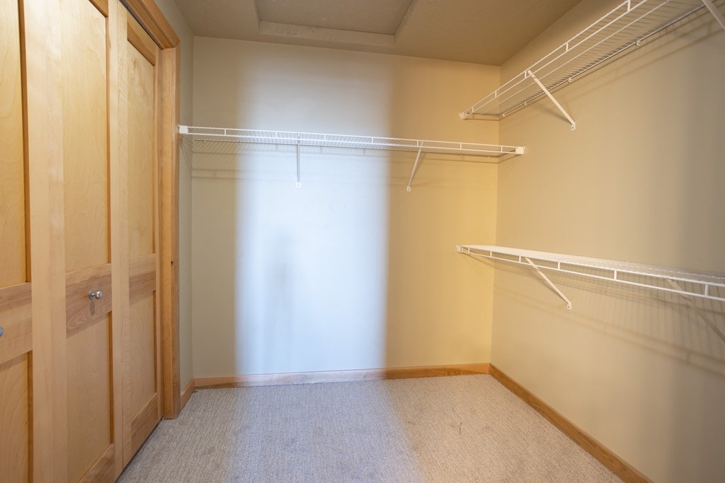 a walk in closet with a sliding glass door