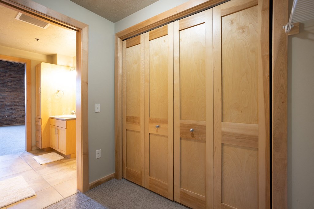 a row of wooden cabinets in a room with a bathroom