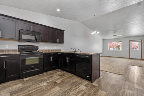 A kitchen with dark wood cabinets and appliances.