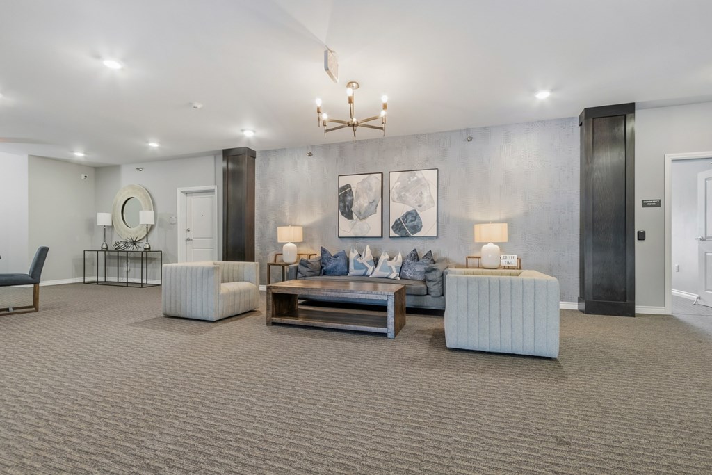 A modern living room with a grey carpet and furniture.