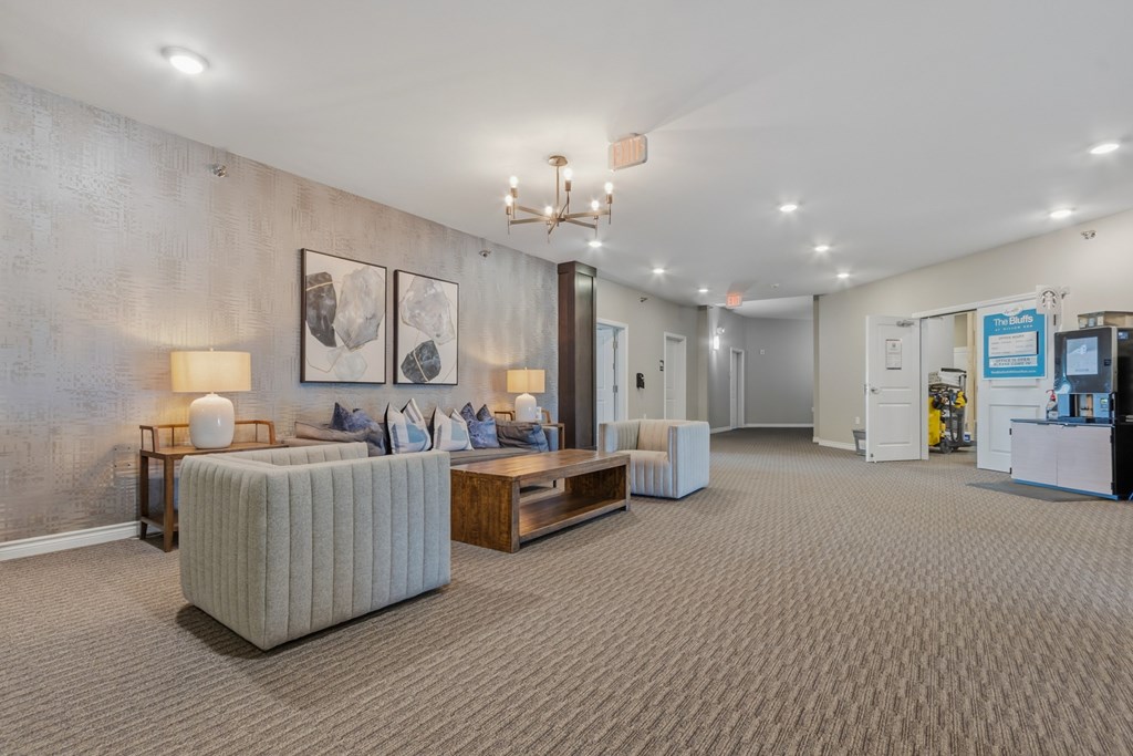 A well-lit waiting room with a grey sofa and a wooden coffee table.