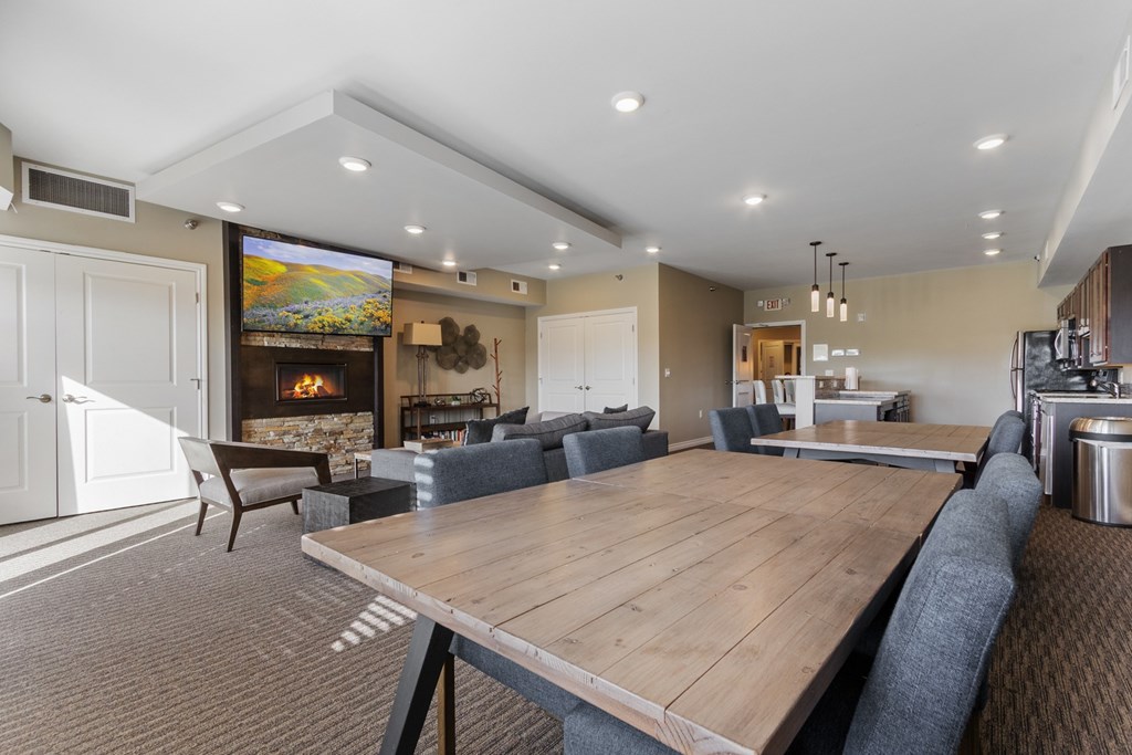 A modern dining room with a large wooden table and grey chairs.