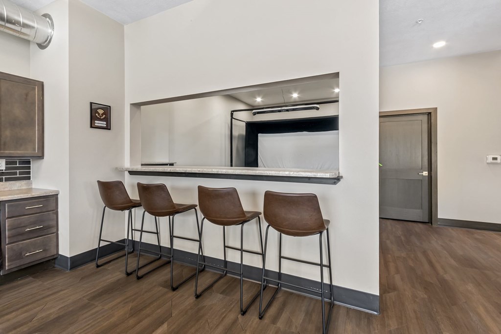 Three brown leather bar stools are placed in front of a mirror.