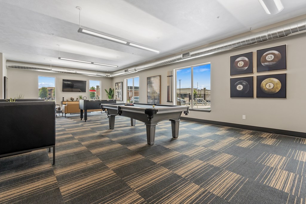 A room with a pool table and a foosball table.