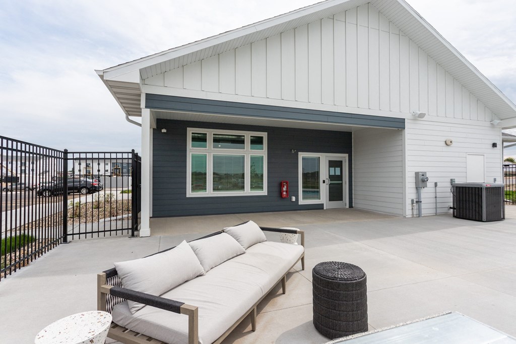 a patio with a couch in front of a house