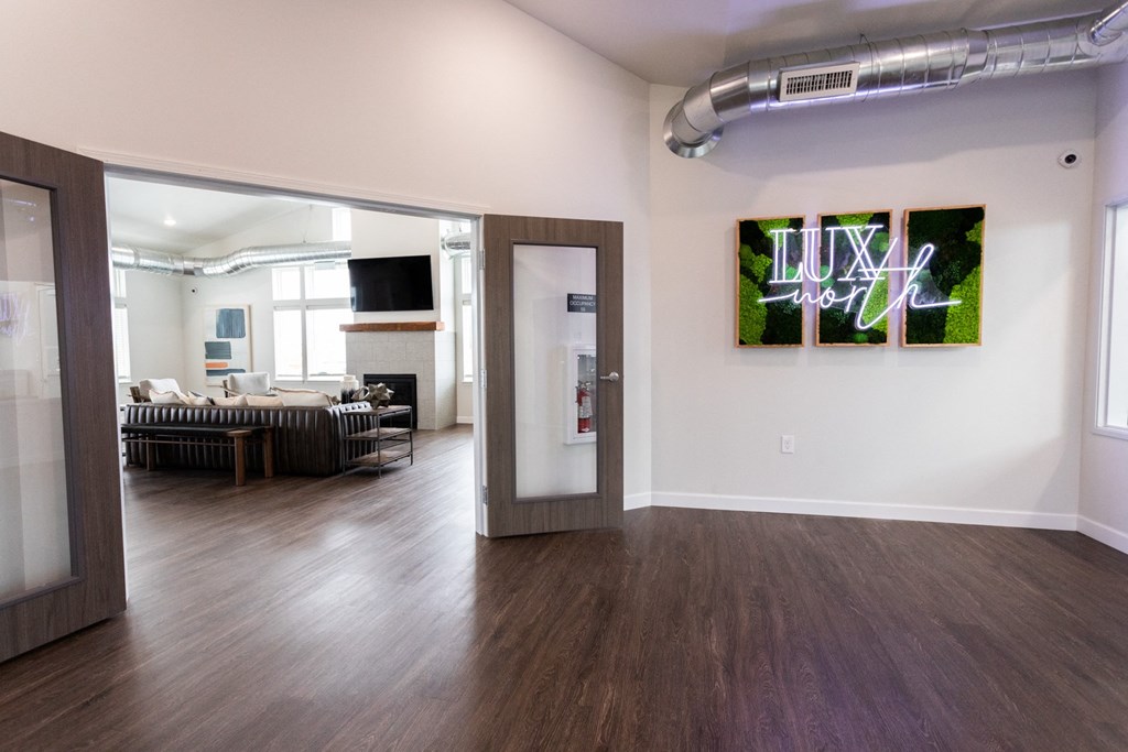 a living room with wood floors and a door to a room with a couch
