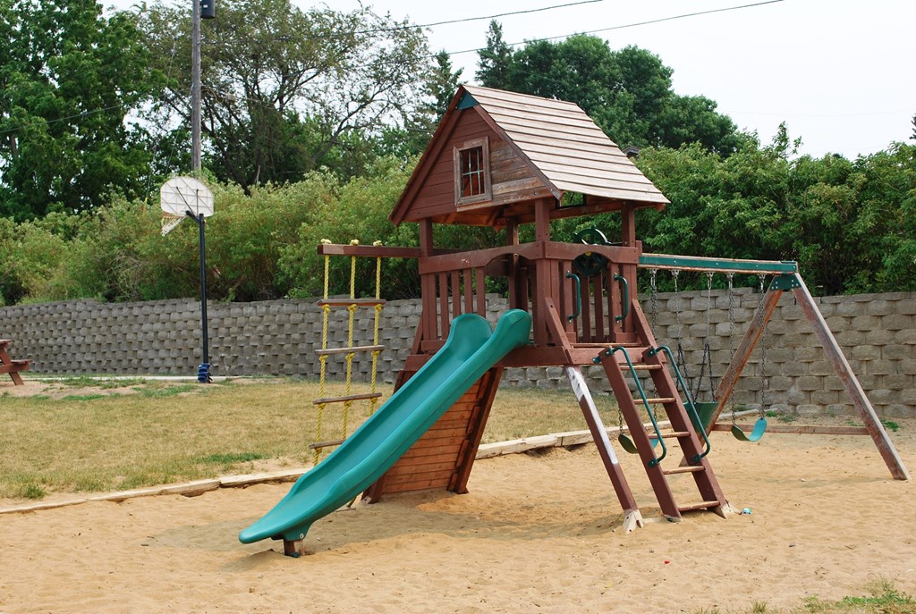 a playset with a slide and a house on top of it