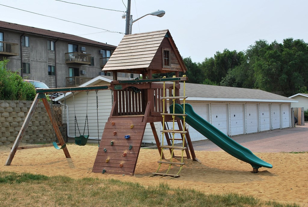 a playset with a house on top of it and a slide