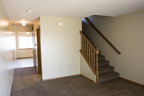 a living room with a staircase and a white wall