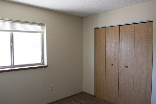 a bedroom with a window and a closet