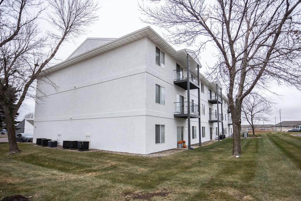 a white apartment building with trees in front of it