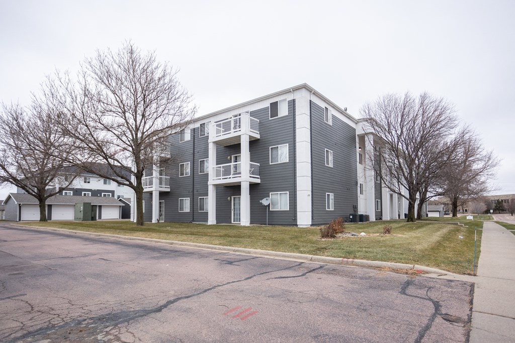 a grey apartment building on the corner of a street