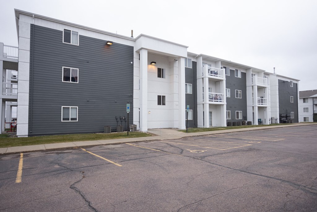 an empty parking lot in front of an apartment building