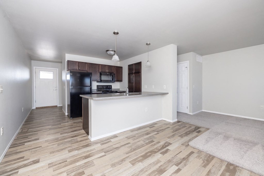 A kitchen area with a white countertop and wooden flooring.