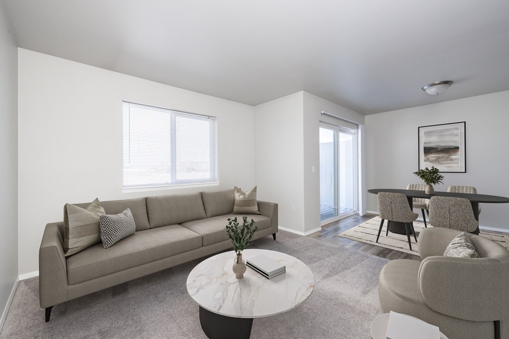 A living room with a grey couch, a white coffee table, and a grey chair.