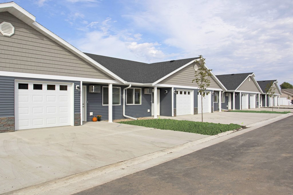 a row of houses with a driveway and a white garage door
