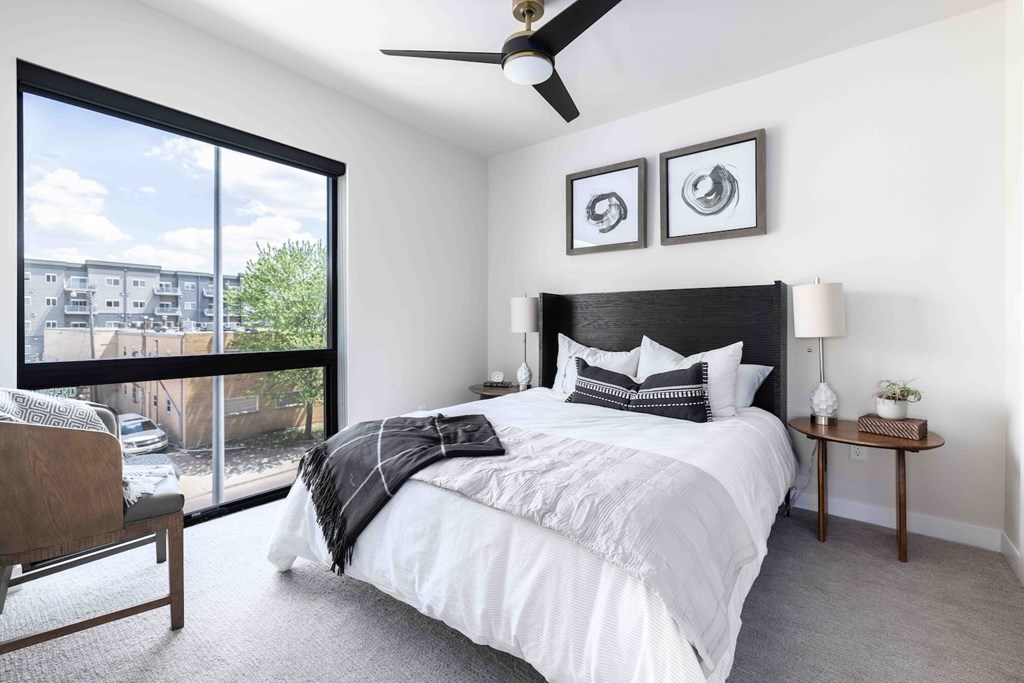 A bedroom with a large bed and a ceiling fan.