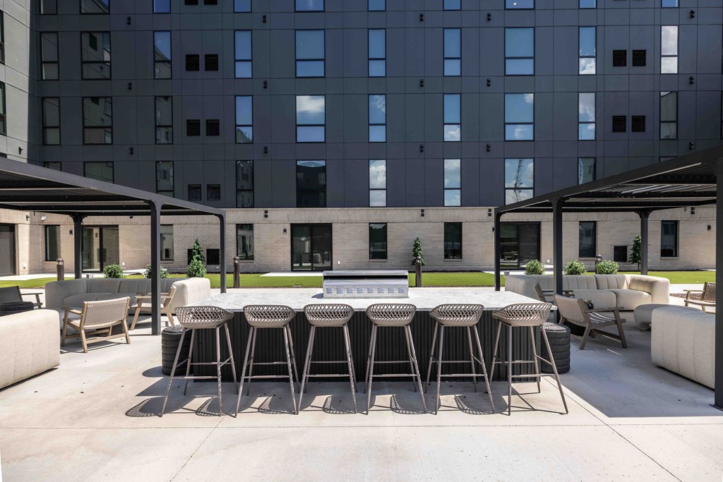 A patio with a table and chairs is in front of a tall building.