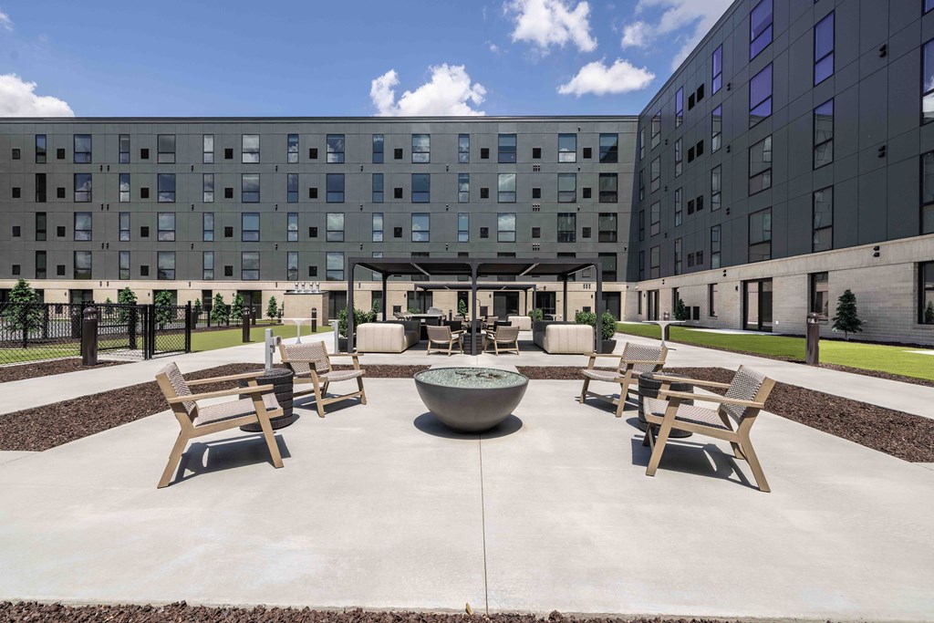 A courtyard with a fountain and benches in front of a building.