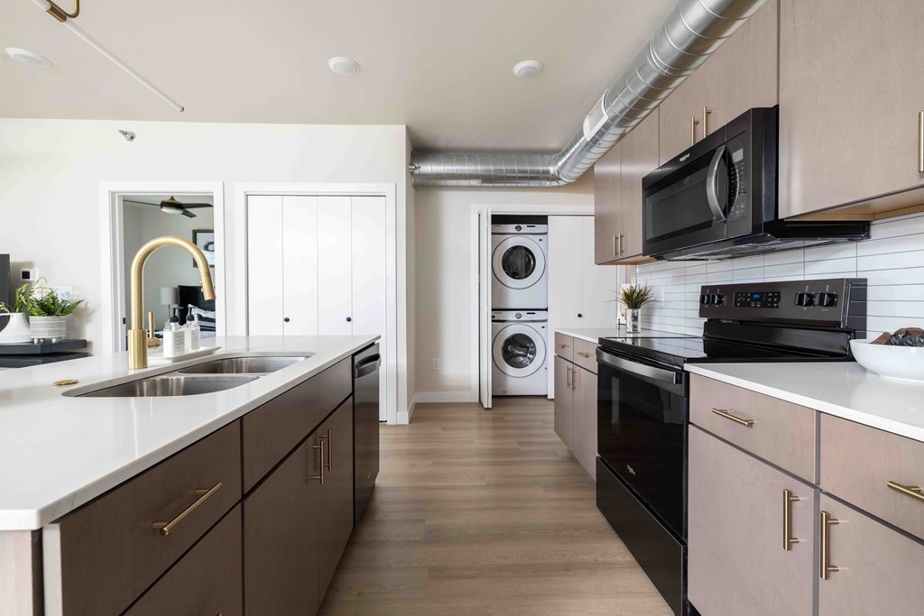 A modern kitchen with dark brown cabinets and white countertops.