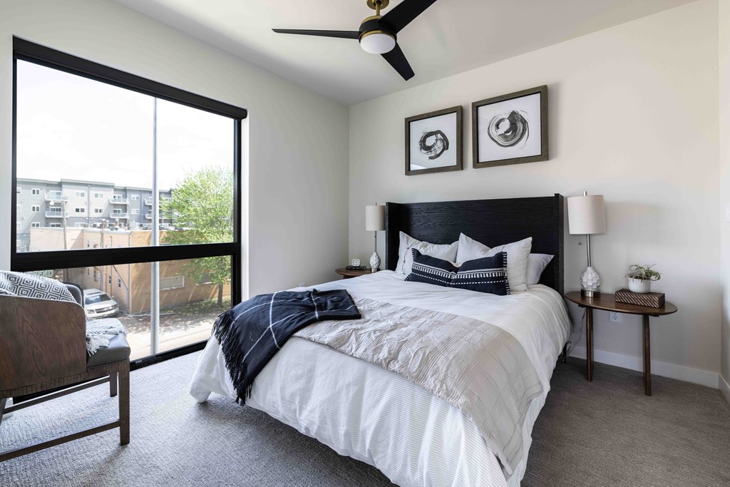 A bedroom with a large bed and a ceiling fan.
