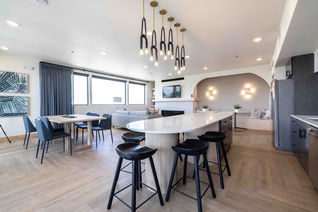 A modern kitchen with a bar area and a dining table.