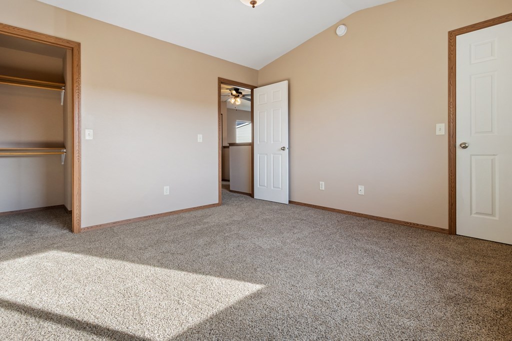 A room with a carpeted floor and a white door.