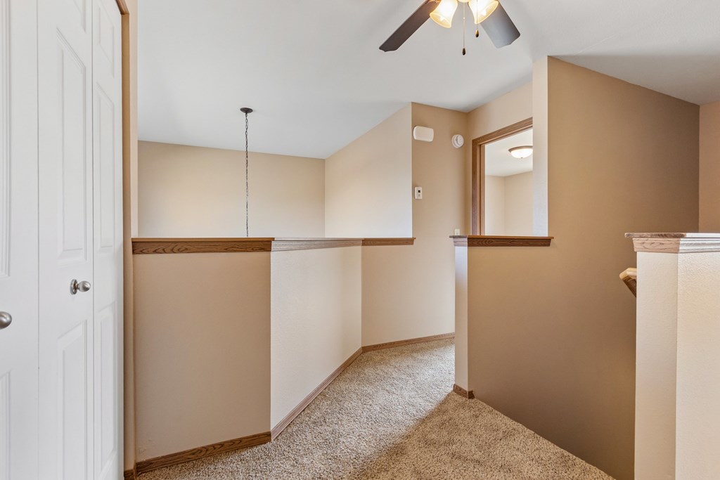 A room with a white door and a ceiling fan.