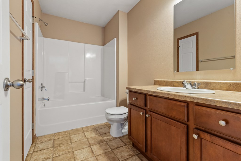 A bathroom with a toilet, sink, and bathtub.