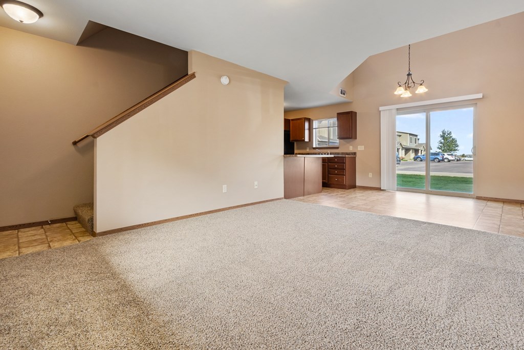 A spacious room with a staircase and a view of the outdoors.