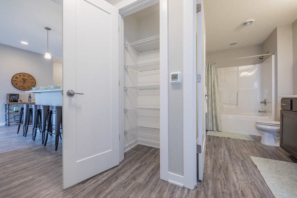 a bathroom with an open shower and a toilet and a kitchen with a bar and