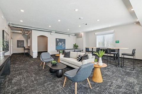 A modern living room with a grey carpet and furniture.