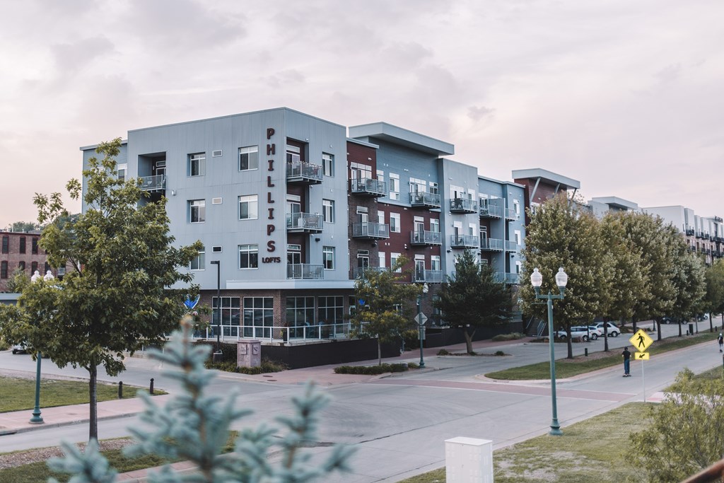 A street view of a residential area with apartment buildings and a pedestrian crossing.