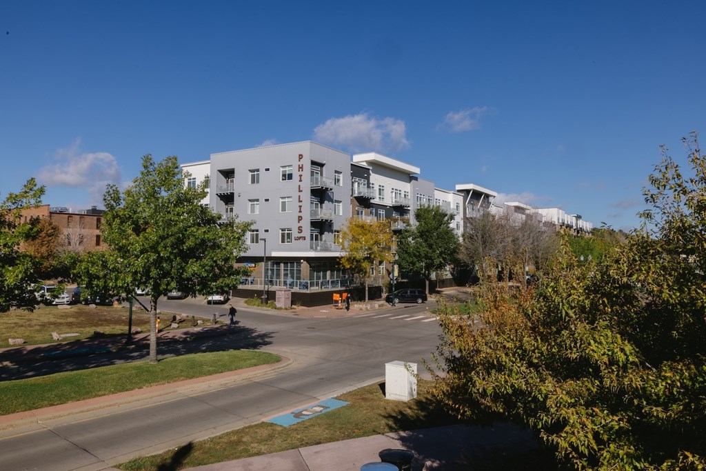 A large white building with a parking lot in front of it.