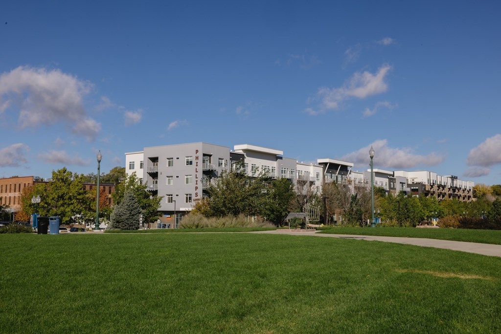 A large white building with a green lawn in front.