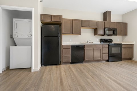A kitchen with brown cabinets and black appliances.