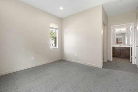 A spacious room with a carpeted floor and a window.