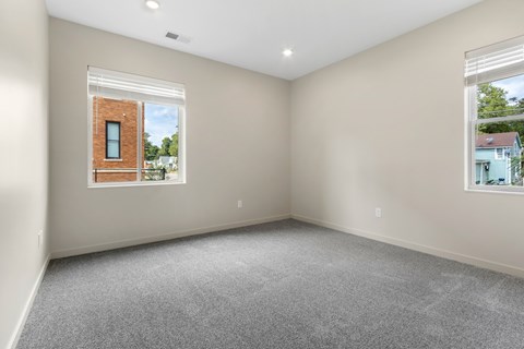 A room with a window showing a brick building outside.