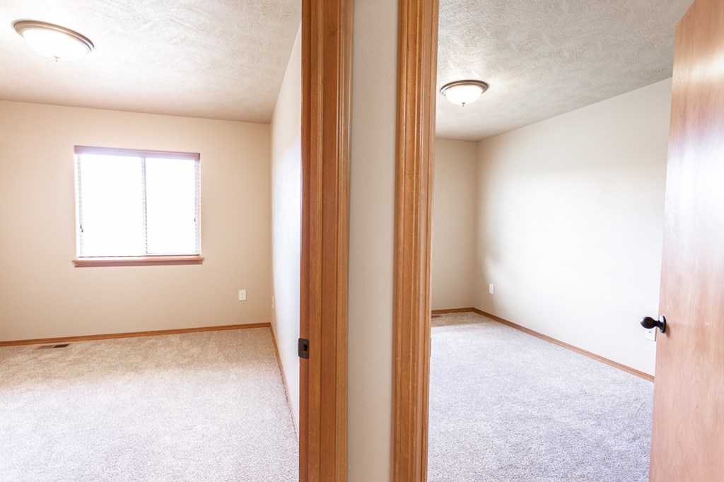 the view of an empty bedroom from the doorway of a new home