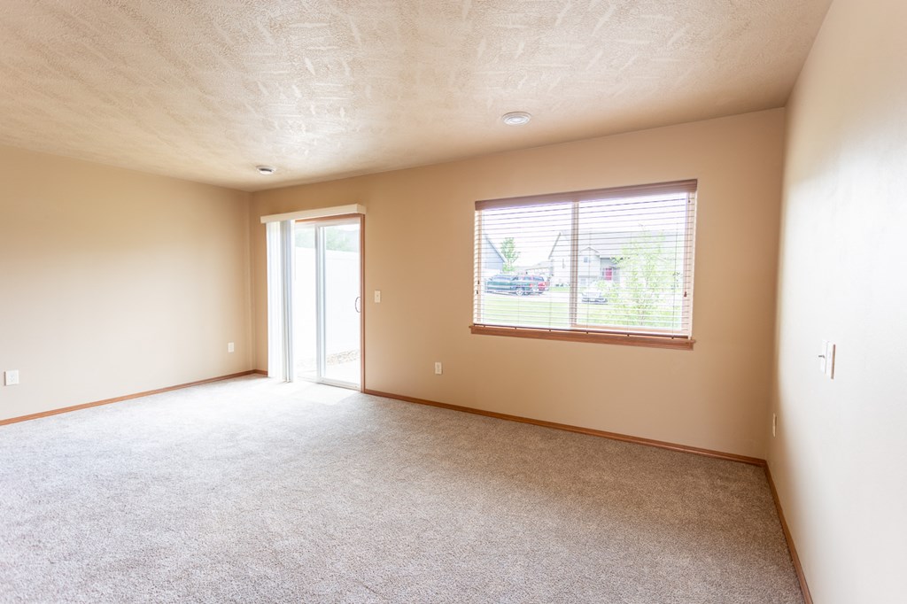 the living room of an empty house with a large window