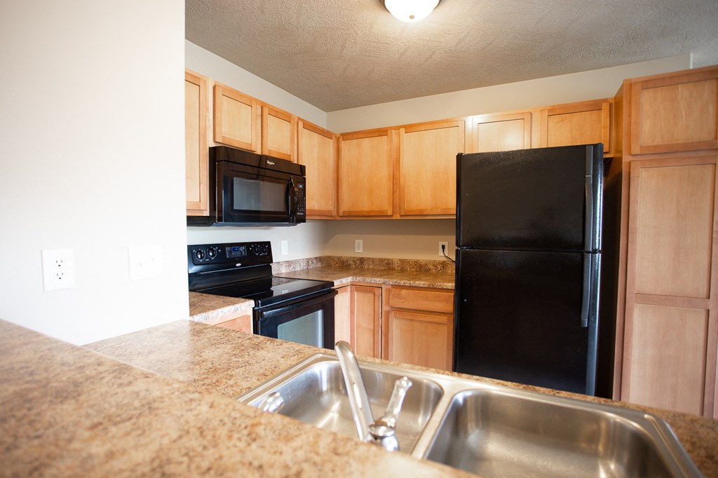 a kitchen with black appliances and granite counter tops
