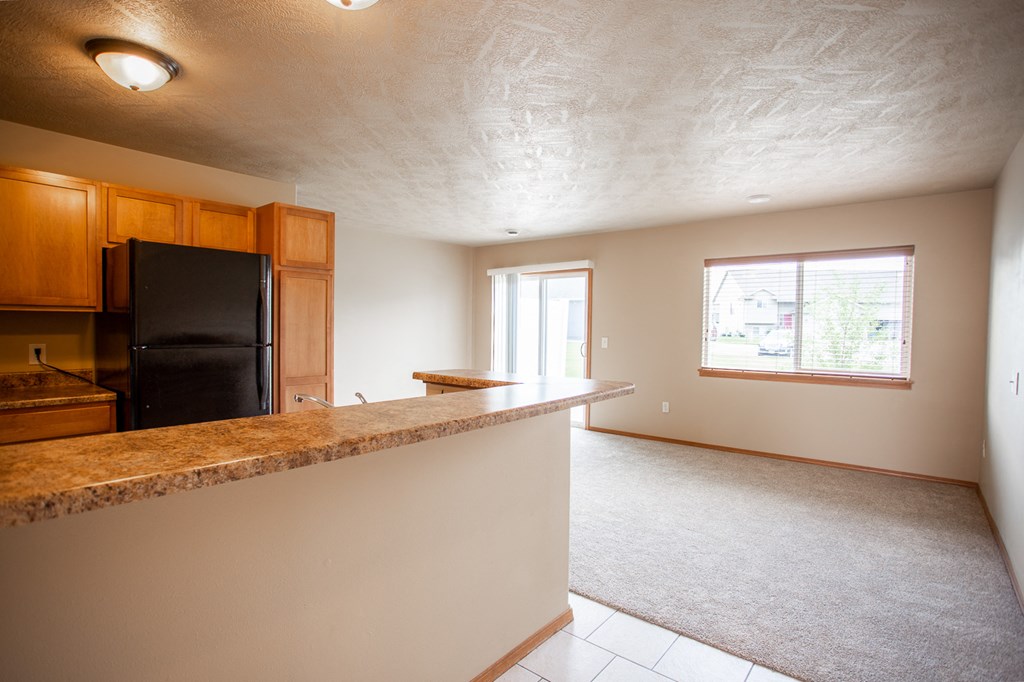 an empty kitchen and living room with a granite counter top