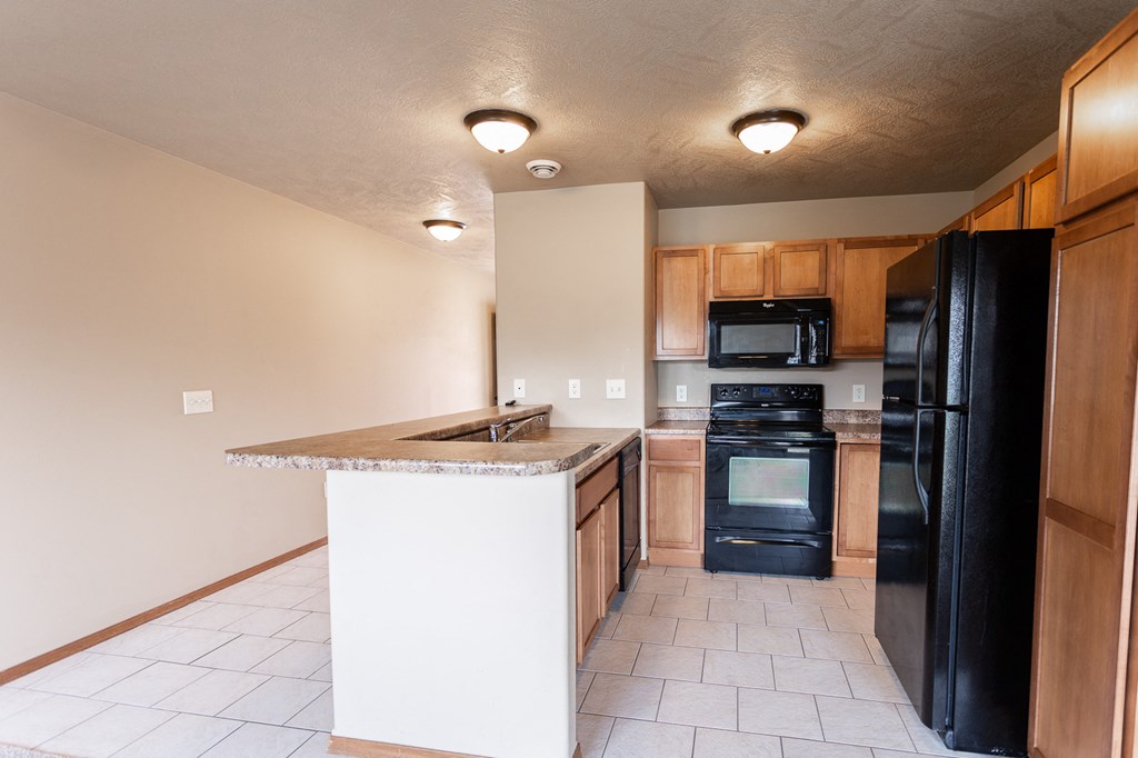 a kitchen with black appliances and a granite counter top