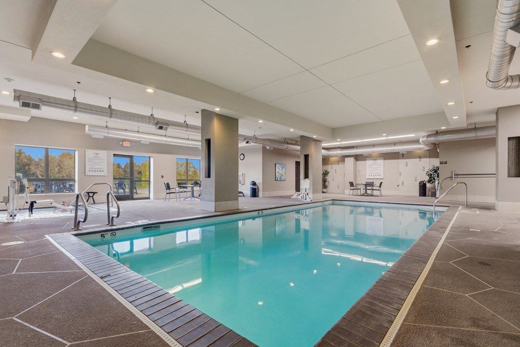 A large indoor swimming pool with a tiled floor and walls.