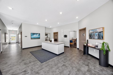 A reception area with a white reception desk and a grey carpet.