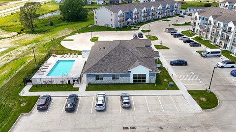 A large white building with a pool in front of it.