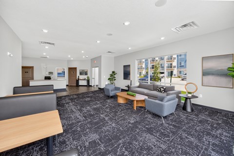 A spacious office lobby with a grey carpet and modern furniture.