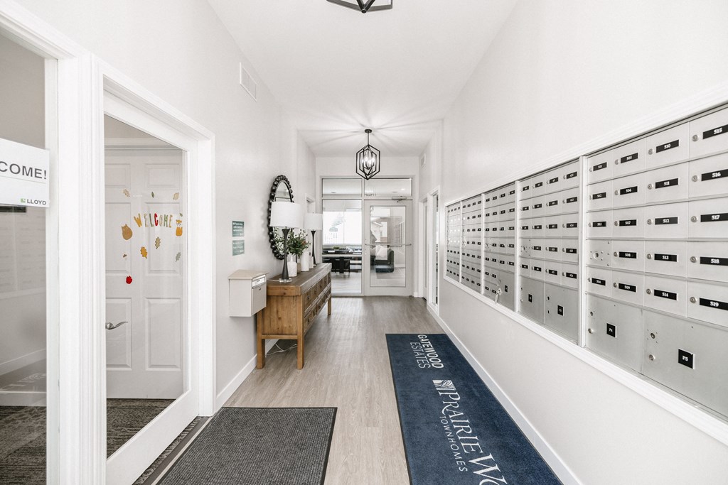 a long hallway with white closets and a blue rug